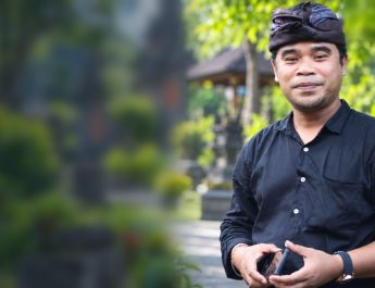 Potret asli Agung Gempa berlatar taman Bali buram, tanpa tulisan dan garis, untuk editorial Bali Membangun