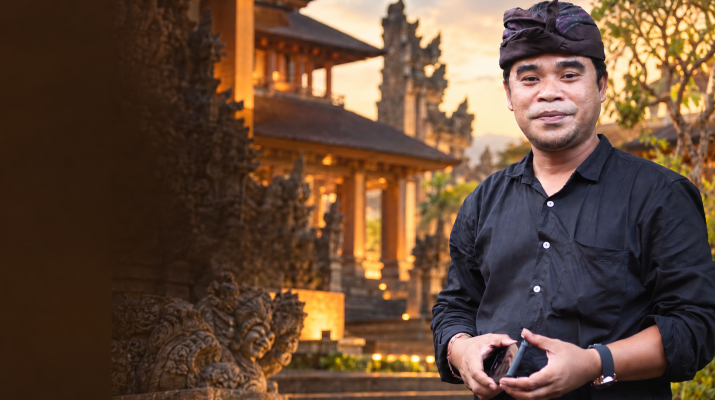 Foto Agung Gempa dengan latar arsitektur Bali bergradasi cokelat, tanpa tulisan